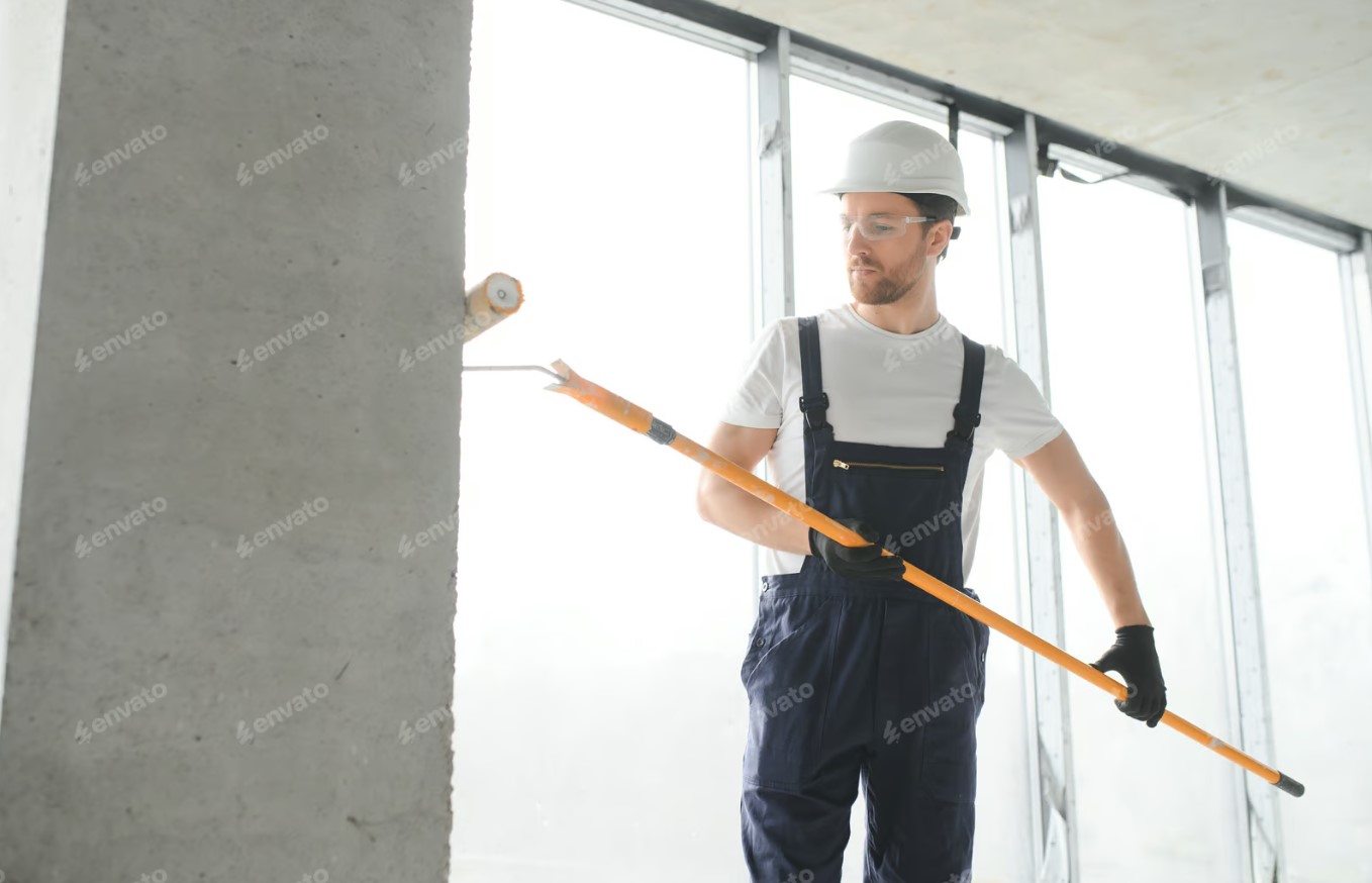 Professional from a painting company using a roller to paint a wall.